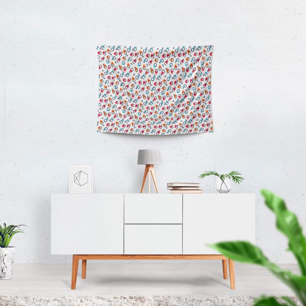 A patterned cute tapestry hangs on the wall, with a table beneath it.