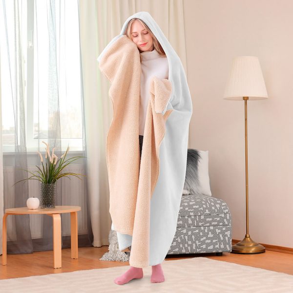 A female model is wearing a pure white hooded blanket and is feeling the temperature of the blanket