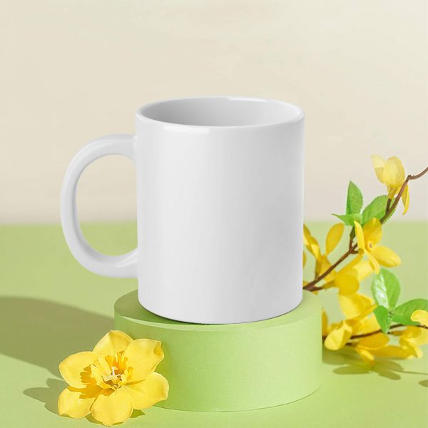 a white ceramic mug is placed on a display stand with flowers