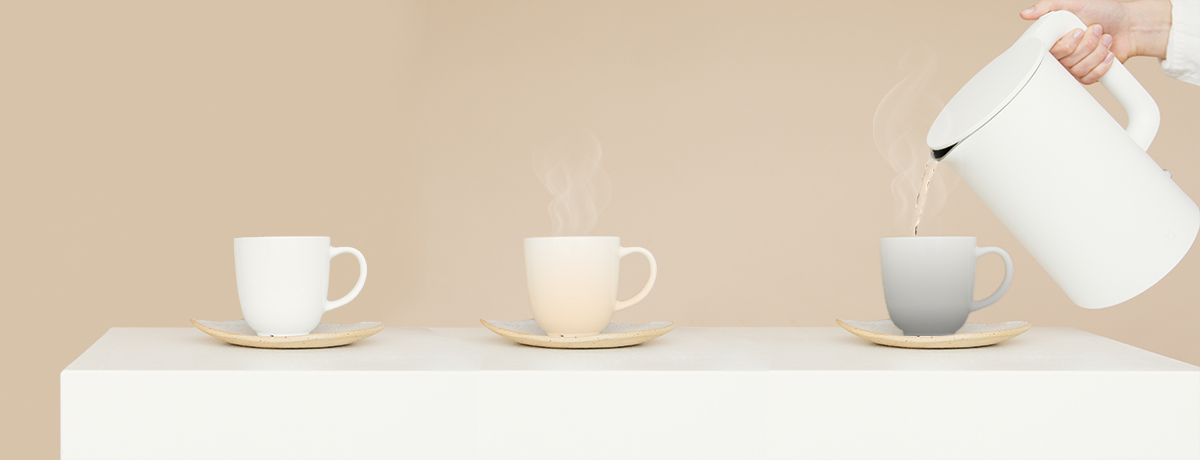 A man with a kettle is pouring water into a color-changing cup