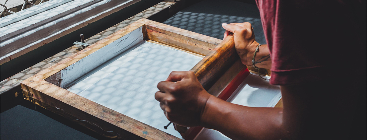 A worker is screen printing