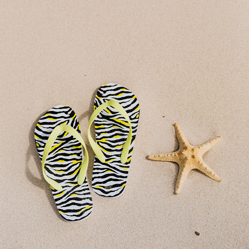 A pair of flip flops placed on the beach