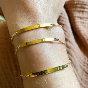 A woman wears three gold custom bracelets