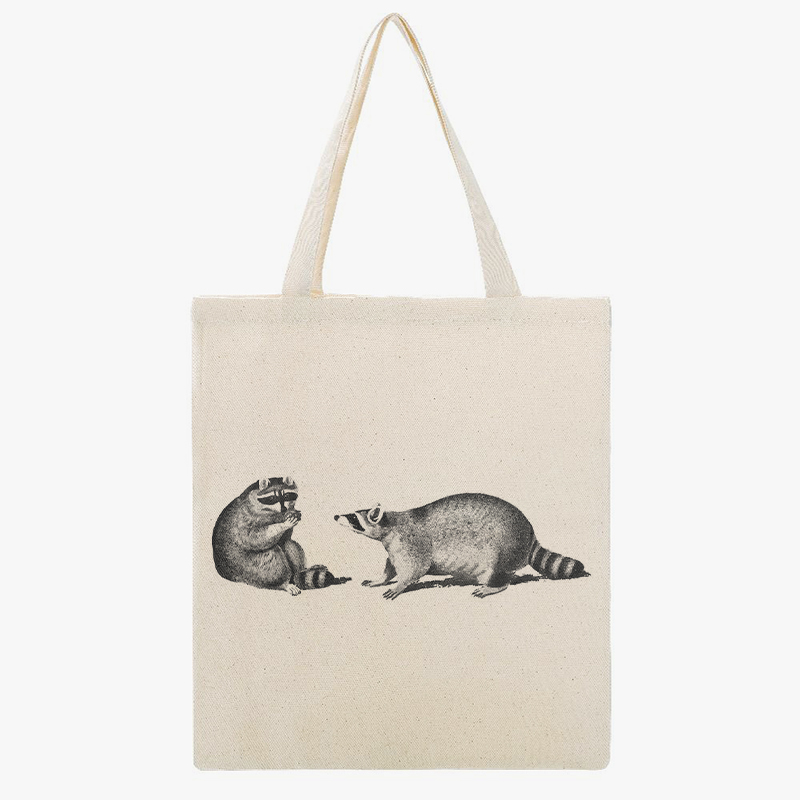 A canvas tote bag with two raccoons