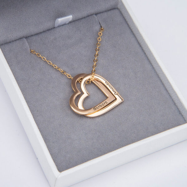 A gold heart necklace is placed in a jewelry box