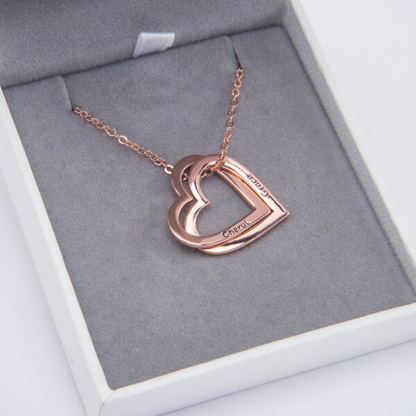 a rose gold heart necklace is placed in a jewelry box