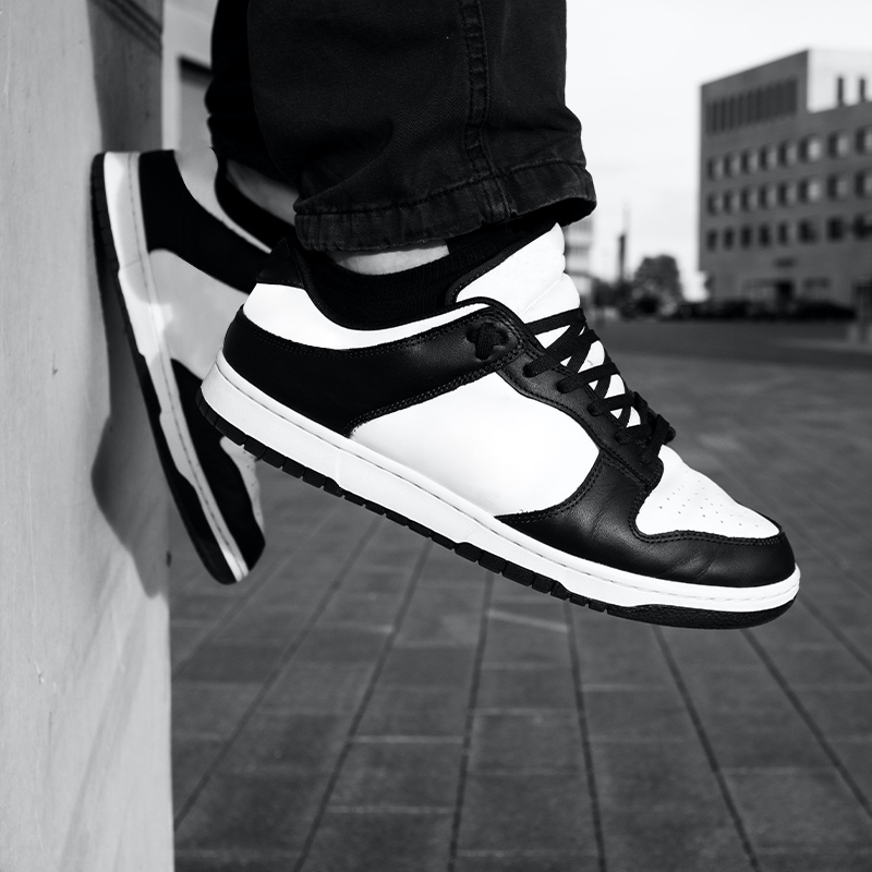 Black and white photo of a person wearing low-top sneakers