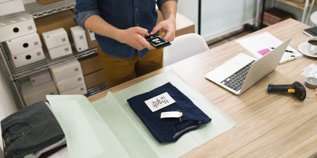 A man scans a black T-shirt with a custom label