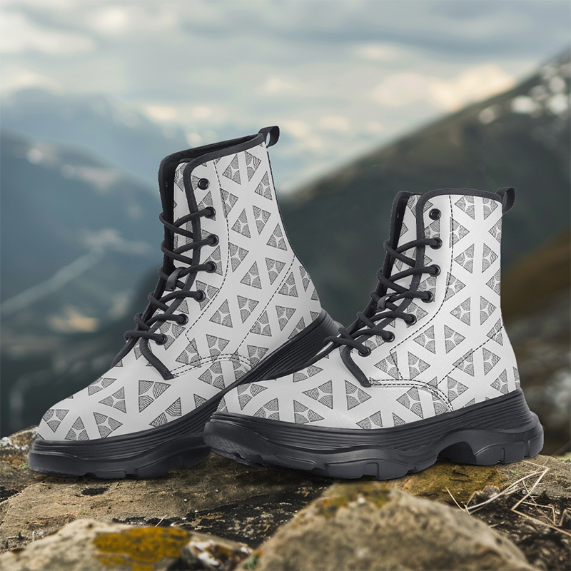 A pair of white boots with patterns are placed on the ground